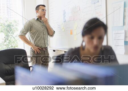 Stock Image - Two people working in office. Fotosearch