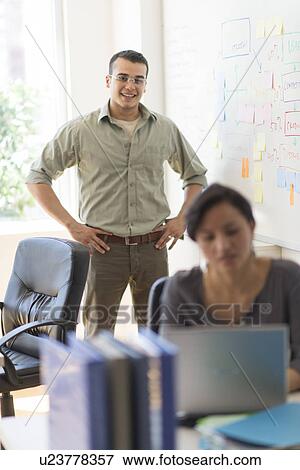 Stock Photo - Two people working in office. Fotosearch