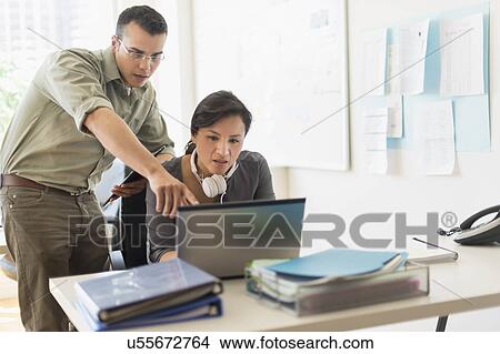 Picture - Two people working together with laptop. Fotosearch