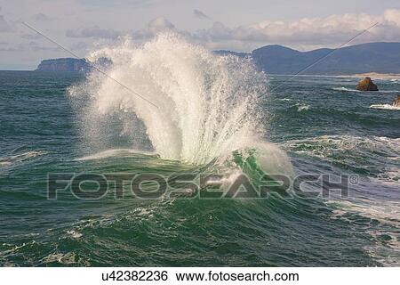 Stock Photograph - Wave splashing on rock. Fotosearch