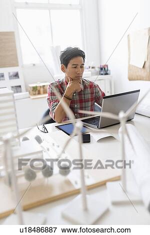 Stock Photo - Wind turbine models on desk in front of architect. Fotosearch