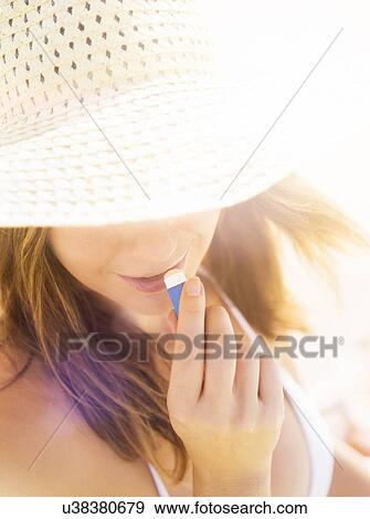 Woman applying lip balm View Large Photo Image Stock Photo - Woman applying lip balm. Fotosearch