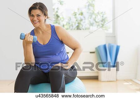 Stock Photo - Woman exercising at gym. Fotosearch