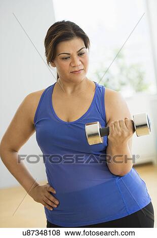 Stock Photo - Woman exercising at gym. Fotosearch