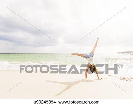 Picture - Woman exercising on beach. Fotosearch