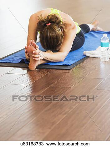 Stock Image - Woman exercising yoga. Fotosearch