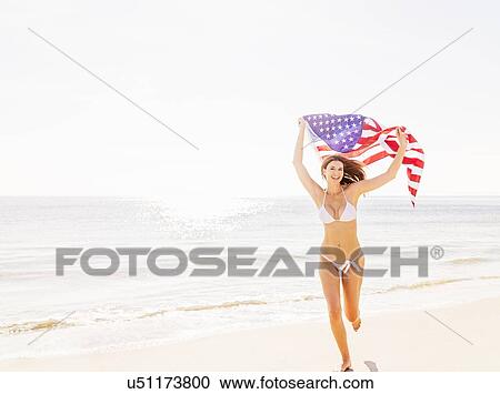 Stock Image - Woman holding American flag. Fotosearch