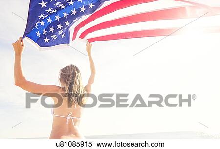 Stock Photography - Woman holding American flag. Fotosearch