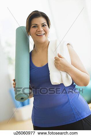 Woman holding exercise mat at gym View Large Photo Image Stock Photo - Woman holding exercise mat at gym. Fotosearch