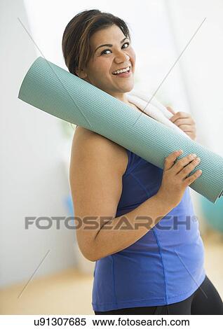 Woman holding exercise mat at gym View Large Photo Image Stock Photography - Woman holding exercise mat at gym. Fotosearch