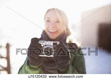 Stock Image - Woman holding old-fashioned camera. Fotosearch
