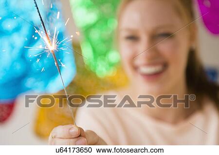 Stock Image - Woman holding sparkler. Fotosearch