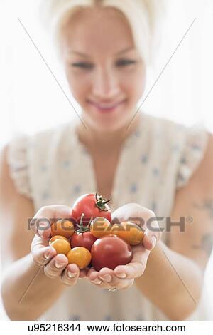 Picture - Woman holding tomatoes. Fotosearch