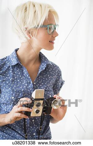 Stock Photo - Woman holding vintage camera. Fotosearch