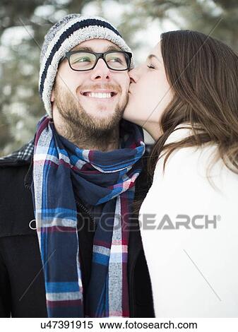 Woman kissing man's cheek outdoors View Large Photo Image Stock Photography - Woman kissing man's cheek outdoors. Fotosearch