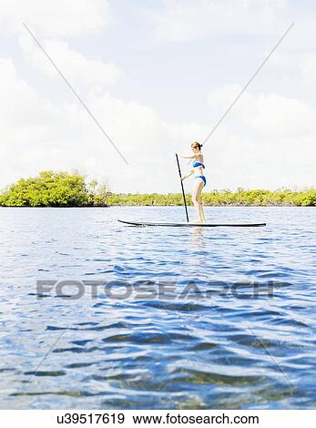 Woman on paddle board View Large Photo Image Stock Photo - Woman on paddle board. Fotosearch