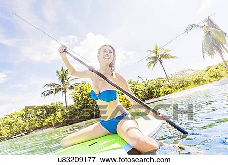 Woman on paddle board View Large Photo Image Stock Photo - Woman on paddle board. Fotosearch