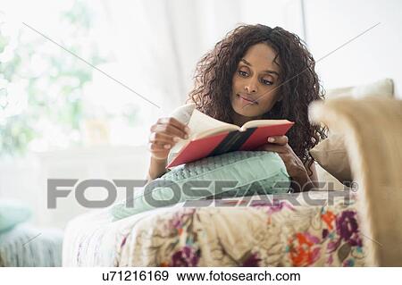 Woman reading book on bed View Large Photo Image Stock Photo - Woman reading book on bed. Fotosearch