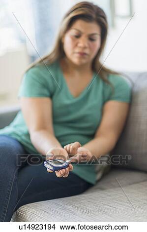 Woman sitting on sofa with mobile phone View Large Photo Image Picture - Woman sitting on sofa with mobile phone. Fotosearch