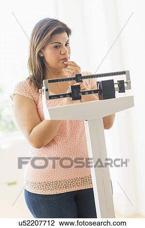 Woman standing on scale View Large Photo Image Stock Image - Woman standing on scale. Fotosearch
