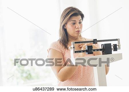 Woman standing on scale View Large Photo Image Stock Photo - Woman standing on scale. Fotosearch