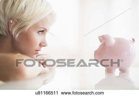 Woman staring at piggy bank View Large Photo Image Stock Image - Woman staring at piggy bank. Fotosearch