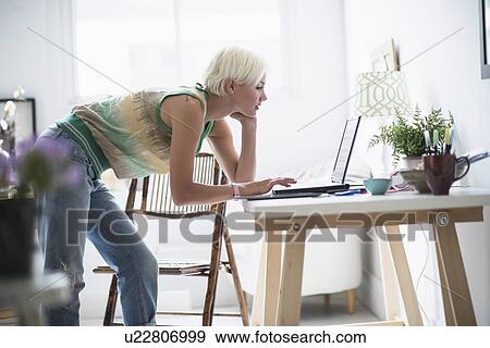 Woman using laptop and at home View Large Photo Image Stock Photo - Woman using laptop and at home. Fotosearch