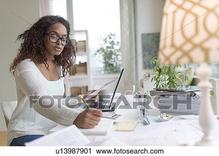 Woman using laptop at home View Large Photo Image Stock Image - Woman using laptop at home. Fotosearch