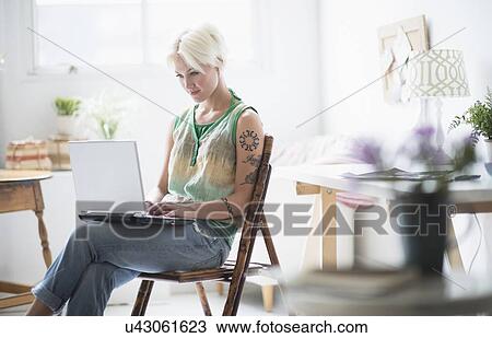 Stock Image - Woman using laptop at home. Fotosearch
