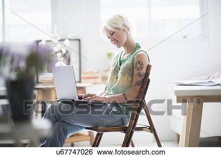 Stock Photograph - Woman using laptop at home. Fotosearch