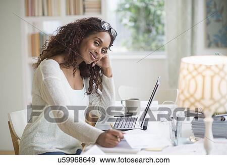 Stock Photo - Woman using laptop in home office. Fotosearch