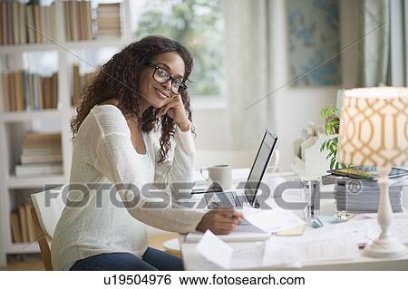 Woman using laptop in home office View Large Photo Image Stock Photograph - Woman using laptop in home office. Fotosearch