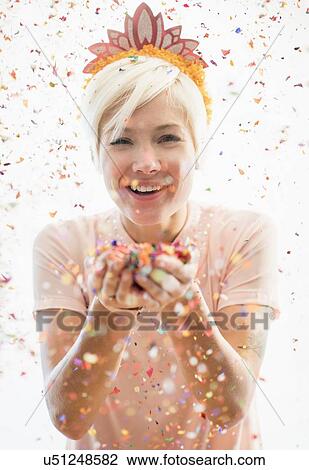 Woman wearing tiara blowing confetti View Large Photo Image Stock Image - Woman wearing tiara blowing confetti. Fotosearch