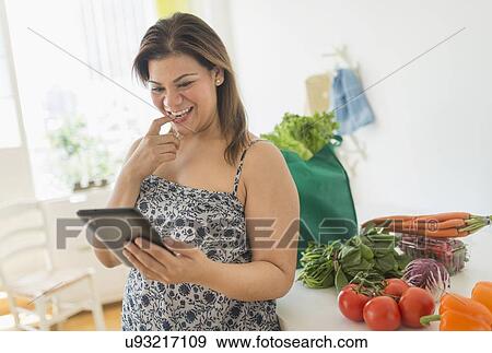 Woman with tablet pc in kitchen View Large Photo Image Stock Photo - Woman with tablet pc in kitchen. Fotosearch