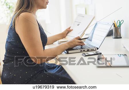 Stock Photo - Woman working in home office. Fotosearch
