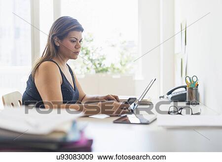 Stock Photo - Woman working in home office. Fotosearch