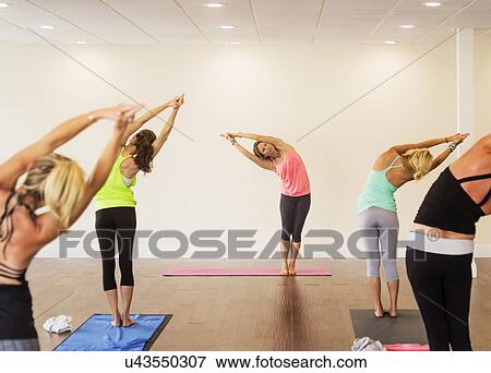 Stock Photo - Women exercising yoga. Fotosearch
