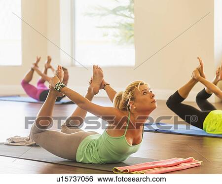 Stock Photograph - Women exercising yoga. Fotosearch