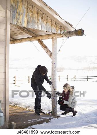 Young couple decorating house with christmas lights View Large Photo Image Stock Photo - Young couple decorating house with christmas lights. Fotosearch