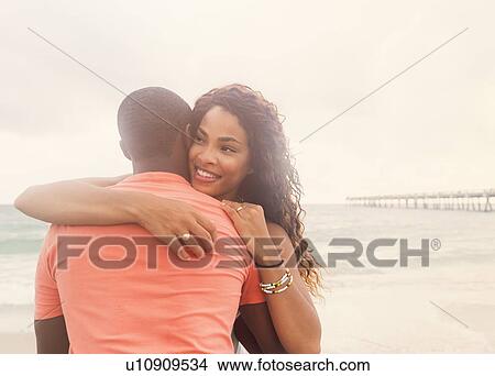Young couple embracing on beach View Large Photo Image Picture - Young couple embracing on beach. Fotosearch