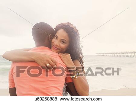 Young couple embracing on beach View Large Photo Image Stock Photo - Young couple embracing on beach. Fotosearch