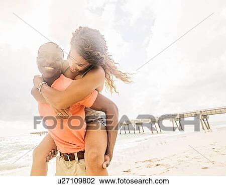 Young couple playing on beach View Large Photo Image Stock Image - Young couple playing on beach. Fotosearch