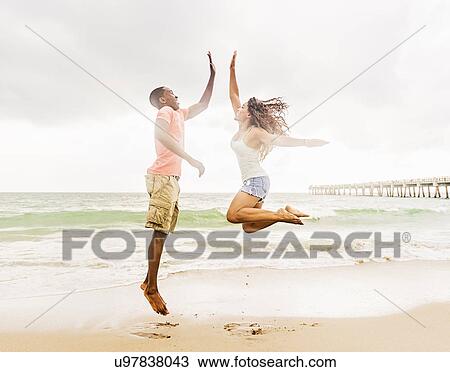 Young couple playing on beach View Large Photo Image Stock Image - Young couple playing on beach. Fotosearch