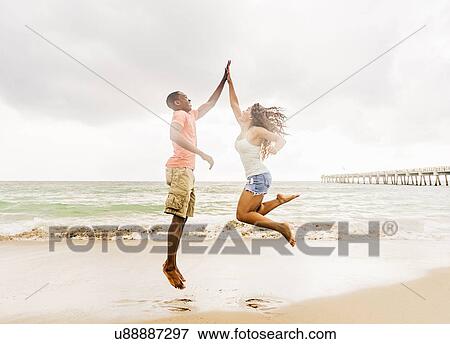 Young couple playing on beach View Large Photo Image Stock Photo - Young couple playing on beach. Fotosearch