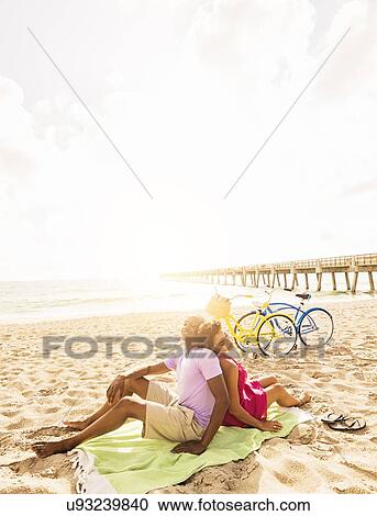 Young couple relaxing on beach View Large Photo Image Stock Image - Young couple relaxing on beach. Fotosearch