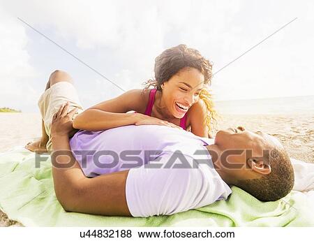 Stock Photo - Young couple relaxing on beach. Fotosearch