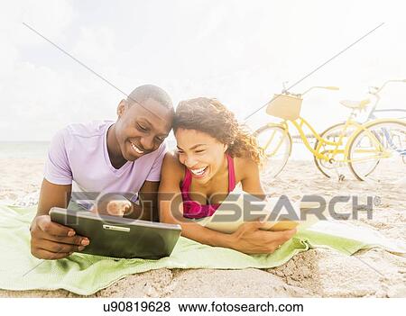 Young couple relaxing on beach View Large Photo Image Stock Photo - Young couple relaxing on beach. Fotosearch