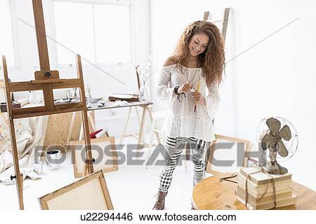 Stock Photograph - Young female artist in studio. Fotosearch