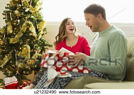 Young man surprised with Christmas gift View Large Photo Image Stock Image - Young man surprised with Christmas gift. Fotosearch