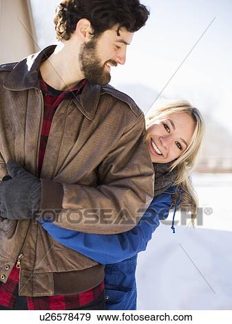 Young woman embracing man in winter View Large Photo Image Stock Photo - Young woman embracing man in winter. Fotosearch